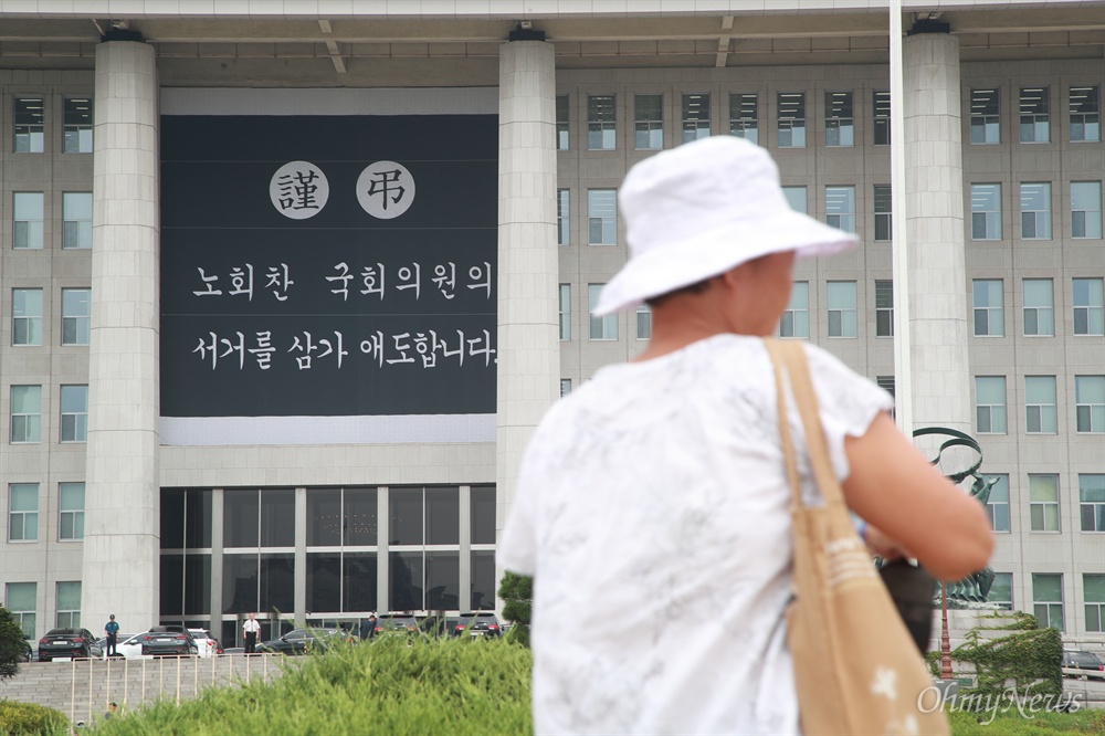  26일 오전 서울 여의도 국회 본관 외벽에 고 노회찬 의원을 추모하는 근조 대형 현수막이 걸려 있다.