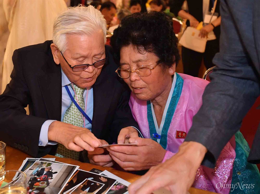  20일 금강산호텔에서 열린 제21차 남북 이산가족 단체상봉 행사에서 남측 유관식(89) 할아버지가 딸 유연옥(67)과 사진을 보고 있다.