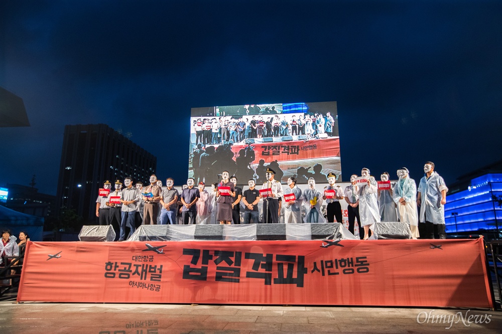  24일 오후 서울 광화문 광장에서 열린 항공재벌 갑질격파 시민행동 집회에서 대한항공, 아시아나항공 직원들이 무대에 올라 가면을 벗을 준비를 하고 있다. 