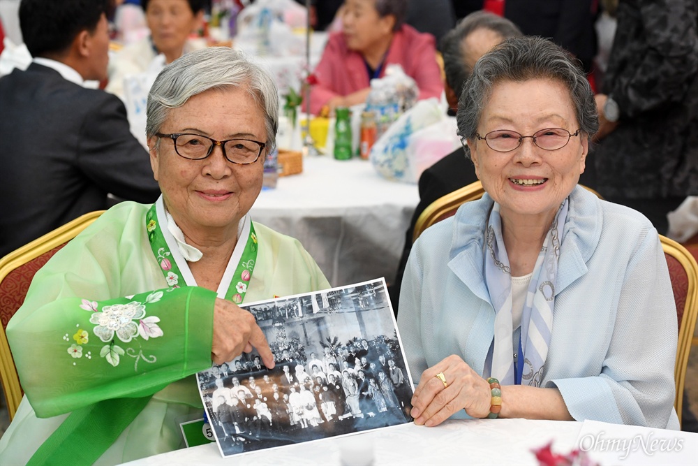  제21차 남북 이산가족 2차 상봉행사 둘째 날인 25일 금강산 면회소에서 열린 단체상봉에서 북측 안세민(80·왼쪽)씨가 가족사진을 보여주고 있다.