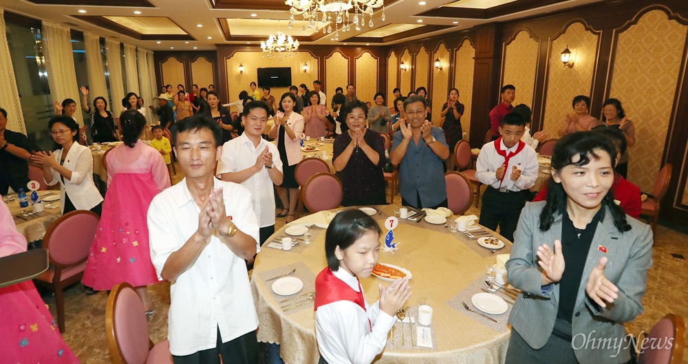  19일 오후 평양 대동강수산물식당에 있던 주민들이 문재인 대통령과 김정숙 여사를 향해 박수치고 있다.