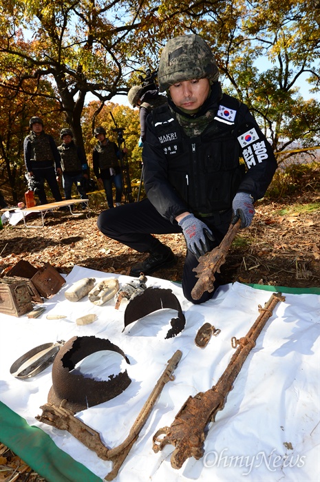  25일 오전 강원도 철원군 철원읍 백마고지 인근 화살머리고지에서 국방부 유해발굴감식단원이 함께 발굴된  6.25 당시 전투 장비를 보여주고 있다. 