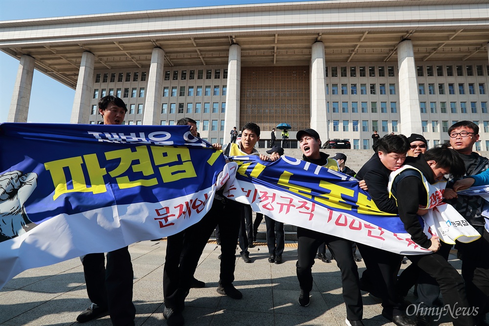  14일 오후 ‘비정규직 그만쓰개 1100만 비정규직 공동투쟁단' 대표들이 국회의사당앞에서 ‘파견법 폐지와 노조법 2조 개정’을 요구하는 현수막을 펼치려다 국회 경위들의 제지를 받고 있다.