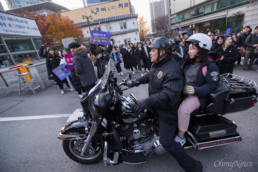  2019학년도 대학수학능력시험이 치러지는 15일 오전 서울 중구 이화여자외국어고등학교에서 수험생 수송 봉사원 오토바이를 탄 수험생이 후배들의 응원을 받으며  시험장으로 향하고 있다.