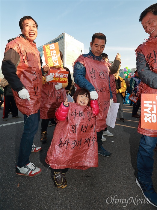 "아빠, 엄마 맘편히 농사짓게 해주세요" 부모와 함께 참석한 한 어린이가 '아빠, 엄마 맘편히 농사짓게 해주세요'가 적힌 마대자루를 입고 방긋 웃고 있다.