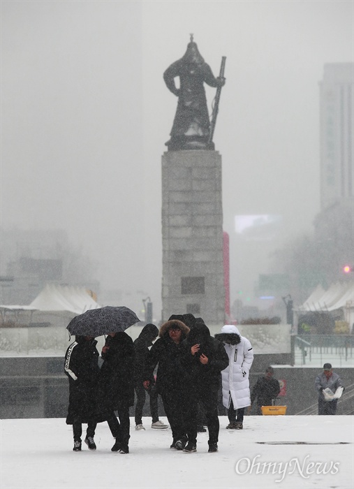  13일 오전 서울 도심에 폭설이 내리는 가운데, 시민들이 잔뜩 움추린 채 광화문광장을 지나고 있다.