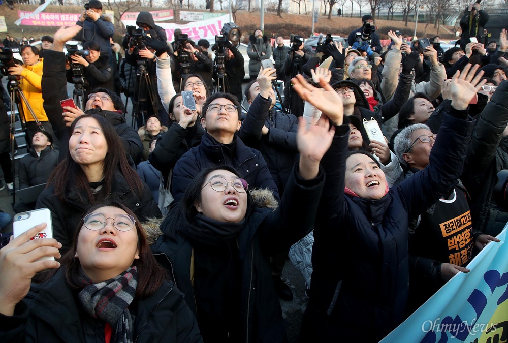 홍기탁-박준호 반기는 시민들 파인텍 노사가 고공농성 426일 만에 협상을 타결한 10일 오후 서울 양천구 목동 열병합발전소 굴뚝 위에서 농성을 벌인 금속노조 충남지부파인텍지회 홍기탁 전 지회장과 박준호 사무장이 농성을 풀고 땅에 내려오자, 마중 나온 시민과 노동자들이 이들에게 손을 흔들며 반기고 있다.