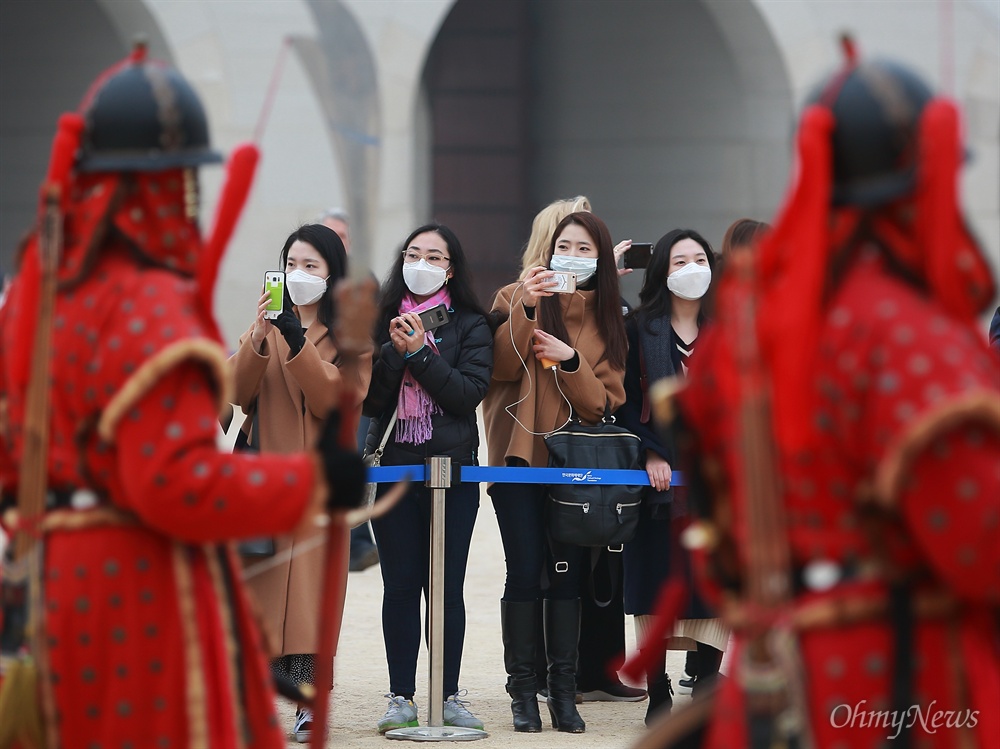  수도권과 전국 곳곳에 미세먼지 비상저감조치가 내려진 14일 오전 서울 경복궁을 찾은 관람객들이 마스크를 착용한 채 수문장 교대식을 지켜보고 있다.