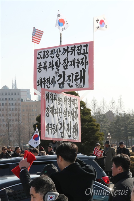 태극기와 성조기 든 김진태 지지자 김진태 자유한국당 의원이 23일 오후 서울 여의도 국회 본관 앞에서 당대표 출마 선언을 하는 동안 한 지지자가 태극기와 성조기를 매단 피켓을 들고 있다.