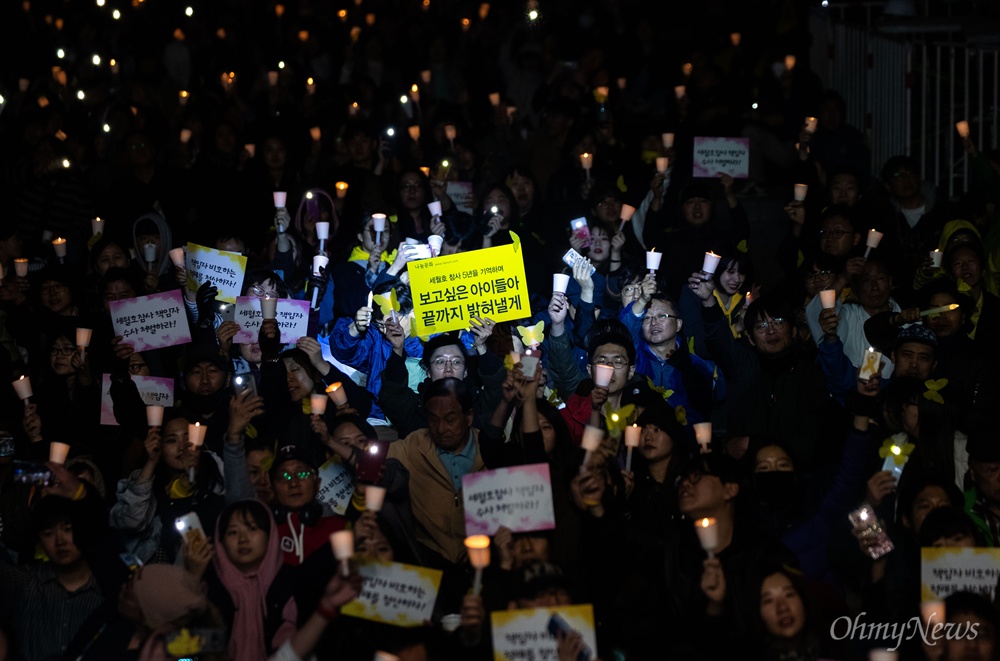  세월호 5주기를 앞둔 13일 오후 서울 광화문 광장에서 열린 세월호참사 5주기 기억문화제에서 참가자들이 촛불과 핸드폰 불빛으로 어둠을 밝히고 있다.