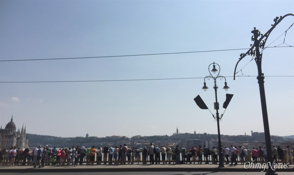  8일(현지시각) 헝가리 부다페스트 다뉴브강 머르깃 다리 위에 헝가리 시민들이 모여 허블레아니 인양 준비 작업을 지켜보고 있다. 머리깃 다리는 전날까지 일시적으로 통행이 금지됐었다. 