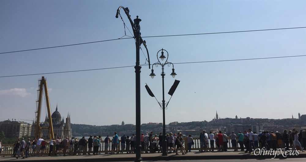  8일(현지시각) 헝가리 부다페스트 다뉴브강 머르깃 다리 위에 헝가리 시민들이 모여 허블레아니 인양 준비 작업을 지켜보고 있다. 머리깃 다리는 전날까지 일시적으로 통행이 금지됐었다. 