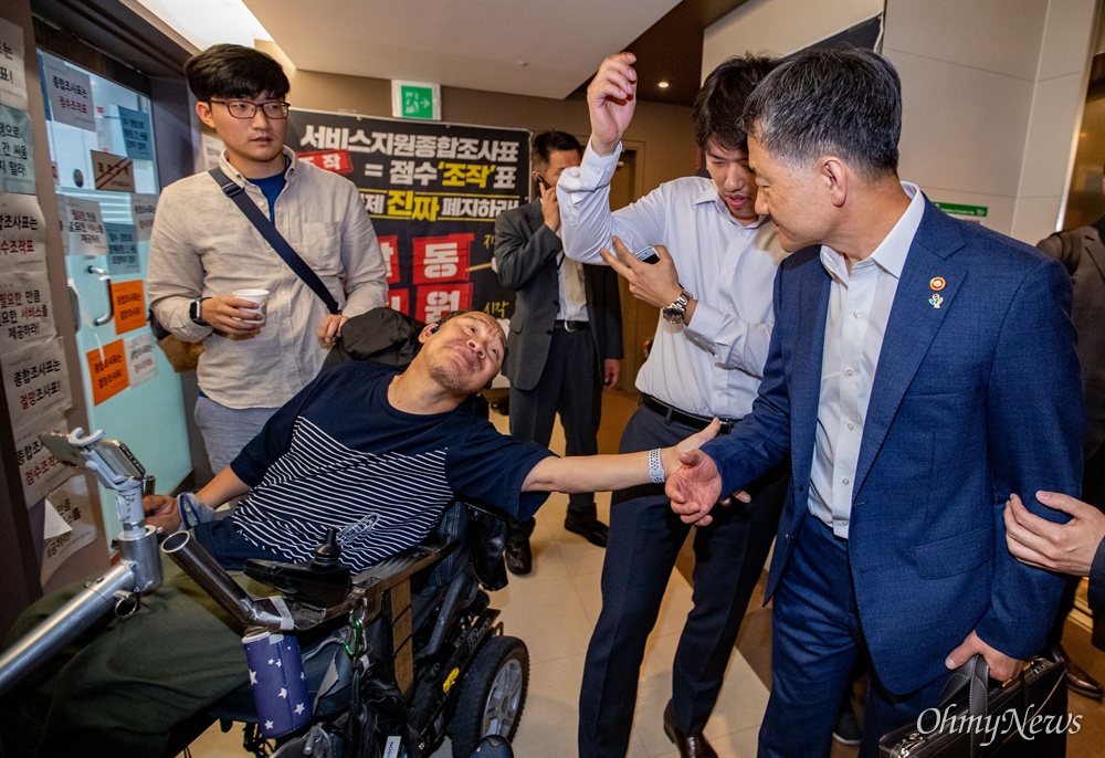  한국장애인자립생활센터협의회 대표단이 14일 오전 서울 종로구 사회보장위원회에서 장애등급제 폐지를 앞두고 종합조사표 전면 수정을 요구하는 농성을 하던 중 내부에 있던 박능후 보건복지부 장관 면담이 긴급 성사 되어 대화를 하고 있다.