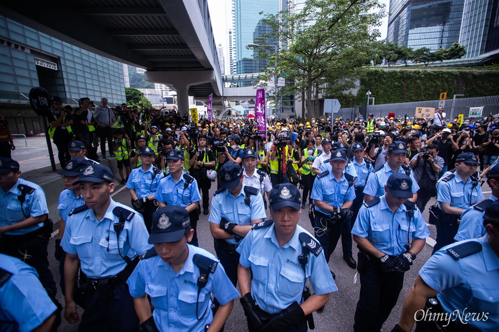  17일 오전 범죄인 인도법(일명 송환법) 폐지를 촉구하는 ‘검은 행진’에 참가한 홍콩 시민들에게 도로점거 철수를 요구하던 경찰들이 자리를 떠나고 있다.