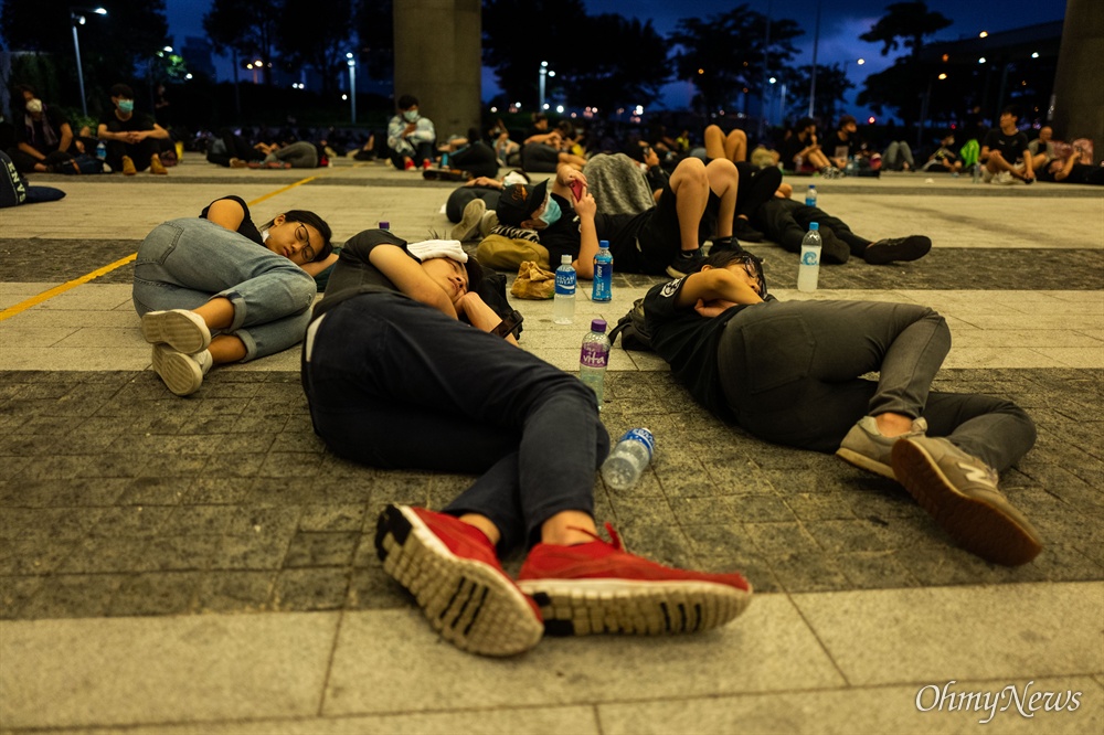  17일 오전 범죄인 인도법(일명 송환법) 폐지를 촉구하는 ‘검은 행진’에 참가한 홍콩 시민들이 중앙정부청사 내 광장에서 평화노래 밤샘 농성을 이어가던 시위 참가들이 바닥에 누워 쪽잠을 자고 있다. 