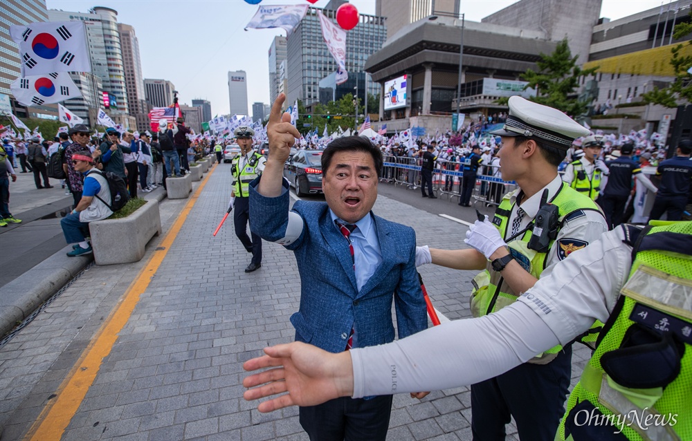 우리공화당 당원이 6일 오후 서울 광화문광장에서 2차 태극기 집회를 마치고 도로로 나와 항의를 하고 있다.
