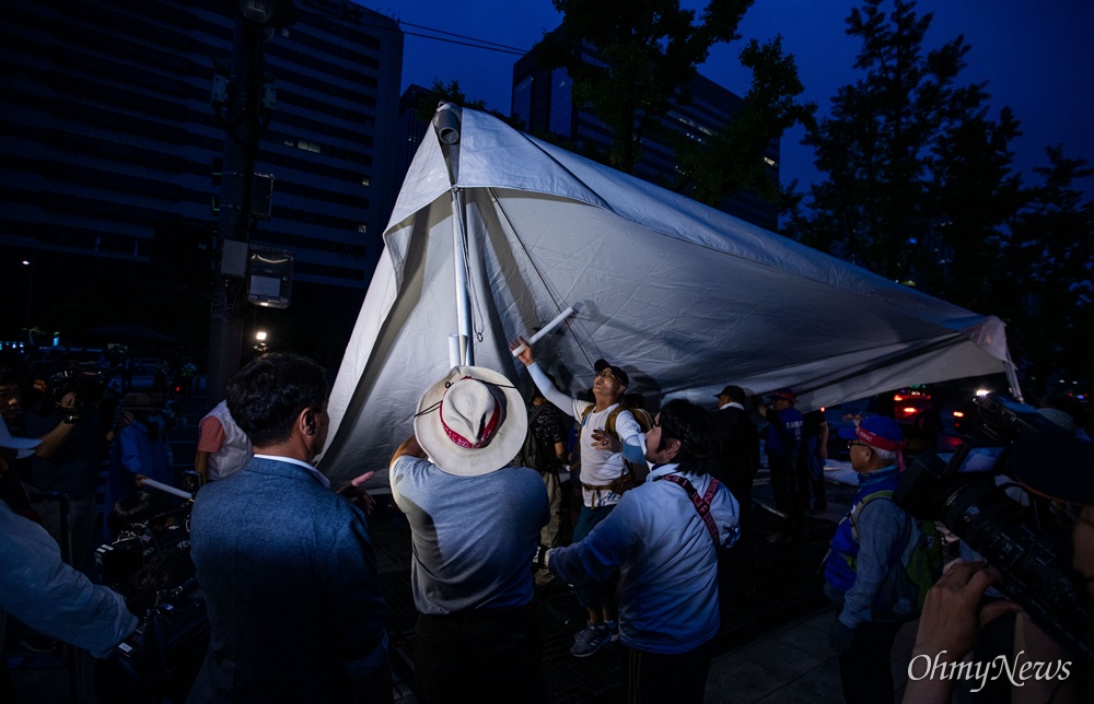  16일 오전 서울 광화문광장에서 천막농성 중이던 우리공화당 조원진 공동대표와 당원들이 강제철거 시한이 되자 세종문화회관 계단 앞으로 천막을 이동하고 있다.