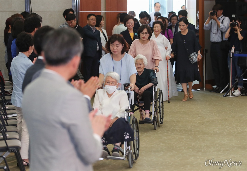  일본군 위안부 피해자 김경애, 이옥선, 이용수 할머니가 14일 오전 서울 용산구 백범김구기념관에서 열린 ‘일본군 위안부 피해자 기림의 날’ 기념식에 입장하자, 참석자들이 기립해 반기고 있다.
