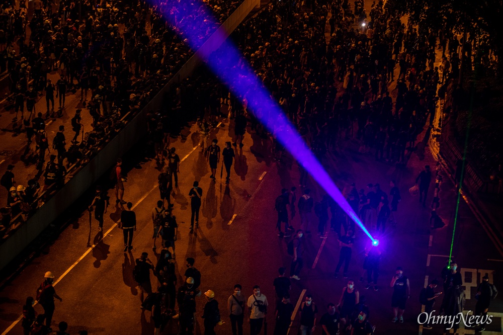  18일 오후 홍콩 중앙정부청사 앞에서 송환법 반대 및 강경진압 규탄 행진을 마친 시위 참가자들이 정부청사를 향해 레이저 포인터를 쏘고 있다. 