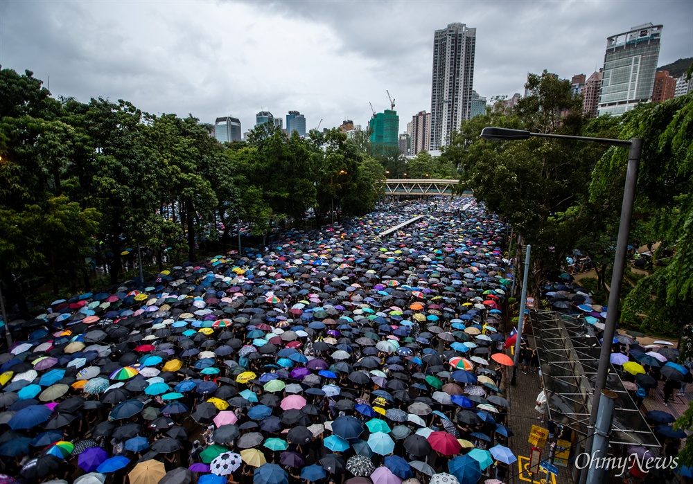 중국 정부의 강경진압 경고에도 불구하고 18일 오후 송환법에 반대하는 홍콩시민들이 빅토리아 공원을 가득 채워 집회를 성사시킨 뒤, 폭우 속에 거리행진을 하고 있다.