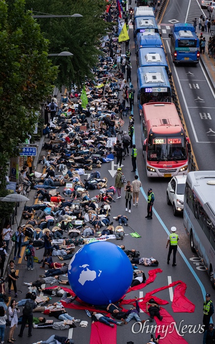  국제 기후 파업 주간인 21일 오후 서울 종각역 사거리에서 열린 9.21 기후위기 비상행동에서 참가자들이 '기후 위기가 다가오면 생존의 위협이 다가온다'는 의미를 가진 퍼포먼스를 하고 있다.