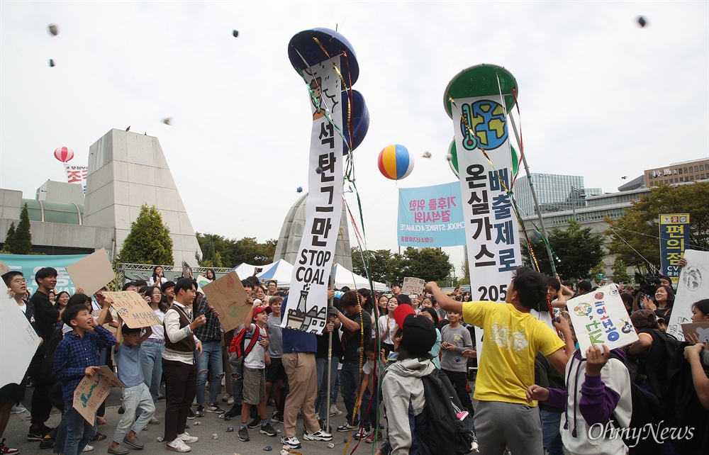  27일 오후 서울 종로구 세종로 공원에서 환경운동단체 청소년기후행동 주최로 열린 ‘기후위기를 위한 결석 시위’에 참석한 학생과 시민들이 기후변화의 심각성을 알리며 평균기온 1.5도 내리는 의지를 표현하는 석탄박 터뜨리기를 하고 있다.