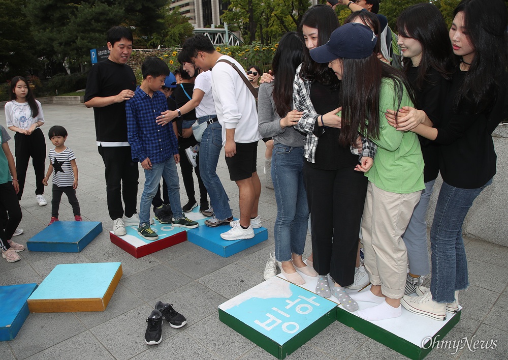  27일 오후 서울 종로구 세종로 공원에서 환경운동단체 청소년기후행동 주최로 열린 ‘기후위기를 위한 결석 시위’에 참석한 학생과 시민들이 기후변화로 빙하가 사라지는 것을 간접 체험하는  게임을 하고 있다.