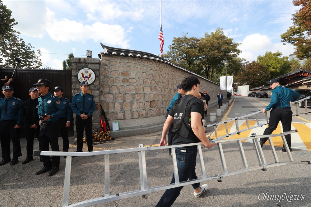 '월담' 시위에 사용된 사다리 들고 가는 경찰들 한국대학생진보연합 소속 대학생들이 과도한 주한미군 방위금 분담금(6조) 요구에 항의하며 18일 오후 서울 중구 덕수궁 뒤편 미대사관저 담장에 사다리를 놓고 넘어들어가는 기습 시위를 벌였다. 뒤늦게 도착한 경찰들이 대학생들이 월담에 이용한 사다리를 옮기고 있다.