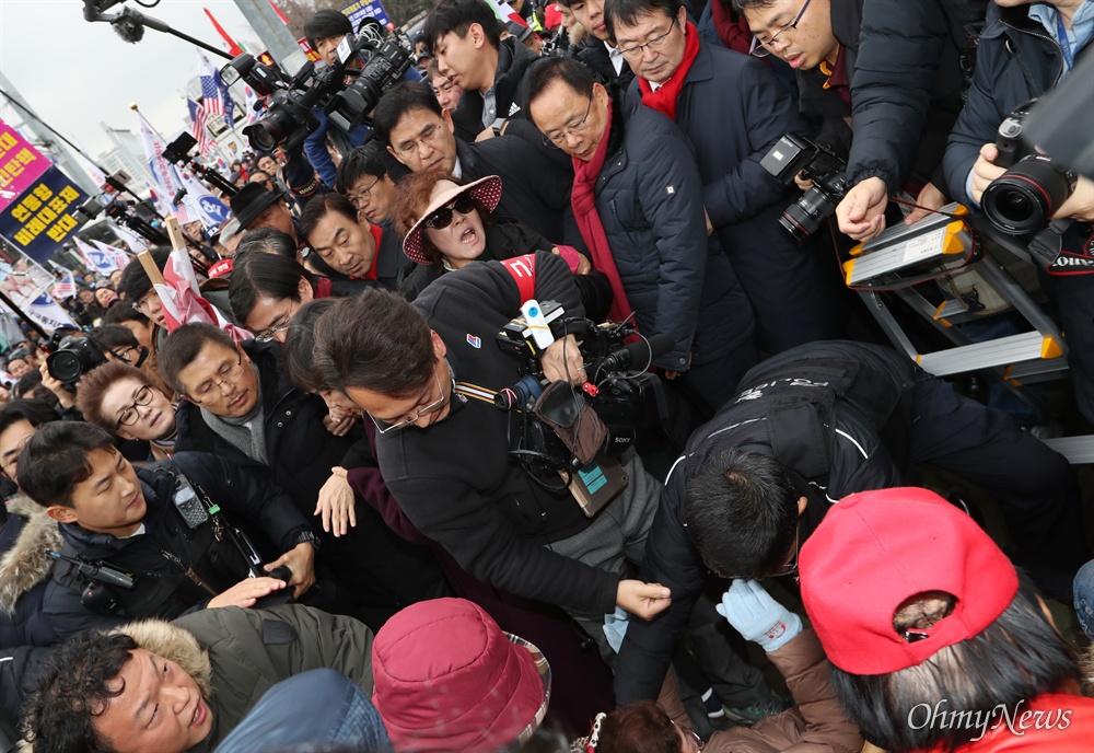 쓰러진 지지자들 옆으로 지나가는 황교안  자유한국당 황교안 대표가 17일 오후 서울 여의도 국회 본관 앞 계단에서 '공수처법 선거법 저지 규탄대회'를 시작한 후, 경내 출입이 제한된 지지자들과 함께 집회를 열기 위해 국회 정문 밖으로 이동하고 있다. 국회 정문을 빠져나온 황 대표가 지지자들과 인사를 나누는 과정에서 이를 취재하는 기자들과 지지자들이 한데 뒤엉켜 3-4명이 쓰러지는 사고가 났다. 경찰이 이들을 부축해 일으켜세우는 모습을 바로 옆에서 황 대표가 쳐다보고 있다. 