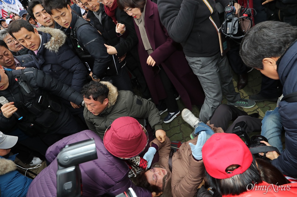 바닥에 나뒹군 지지자들...지나친 황교안 자유한국당 황교안 대표가 17일 오후 서울 여의도 국회 본관 앞 계단에서 열기로 한 '공수처법 선거법 저지 규탄대회'에 출입 제한조치로 자유한국당 당원 및 지지자들이 들어올 수 없게 되자, 황 대표가 지지자들이 있는 국회 정문 밖으로 걸어나오고 있다.  
국회 정문 앞에 모여 있던 지지자들이 황 대표를 맞이하는 과정에서 수많은 인파가 한꺼번에 몰리면서 서너 명이 쓰러지는 사고도 발생했다. 이를 취재하던 기자들도 취재용 사다리 위에서 중심을 잃고 일부 넘어면선 순간 아수라장이 됐다. 
아스팔트 바닥에 쓰러진 이들에게 경찰과 기자들이 번갈아 손을 뻗어 일으켜세운데 반해, 황 대표와 조경태·김순례 최고위원, 박대출 의원 등은 잠시 눈길만 줬을 뿐 별도의 조치 없이 그대로 이들을 지나쳤다. 