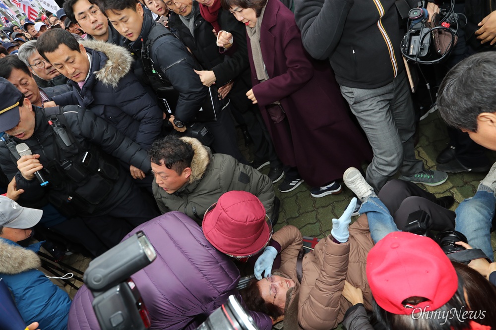 바닥에 나뒹군 지지자들...지나친 황교안 자유한국당 황교안 대표가 17일 오후 서울 여의도 국회 본관 앞 계단에서 열기로 한 '공수처법 선거법 저지 규탄대회'에 출입 제한조치로 자유한국당 당원 및 지지자들이 들어올 수 없게 되자, 황 대표가 지지자들이 있는 국회 정문 밖으로 걸어나오고 있다.  
국회 정문 앞에 모여 있던 지지자들이 황 대표를 맞이하는 과정에서 수많은 인파가 한꺼번에 몰리면서 서너 명이 쓰러지는 사고도 발생했다. 이를 취재하던 기자들도 취재용 사다리 위에서 중심을 잃고 일부 넘어면선 순간 아수라장이 됐다. 
아스팔트 바닥에 쓰러진 이들에게 경찰과 기자들이 번갈아 손을 뻗어 일으켜세운데 반해, 황 대표와 조경태·김순례 최고위원, 박대출 의원 등은 잠시 눈길만 줬을 뿐 별도의 조치 없이 그대로 이들을 지나쳤다. 
