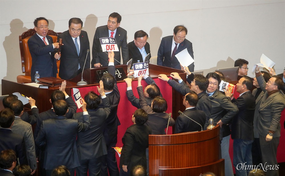  문희상 국회의장이 23일 오후 서울 여의도 국회 본회의에서 의사 일정을 변경 동의를 통해 패스트트랙(신속처리안건 지정) 선거법 개정안을 상정하자, 자유한국당 의원이 단상에 나와 항의하고 있다.