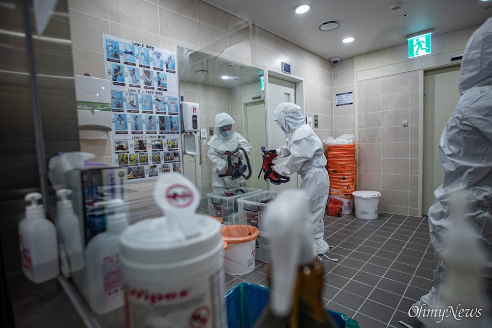  분당서울대병원 39 감염관리병동 간호사가 교대 시간이 되어 방호복 위에 착용한 산소 필터를 분리하고 있다.