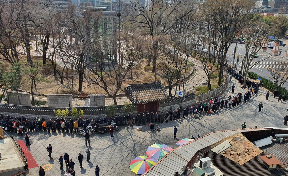  25일 서울 탑골공원 돌담길에는 많은 어르신들이 줄을 서서 무료급식을 기다리고 있다. 탑골공원은 2월 20일부터 문을 닫았다.