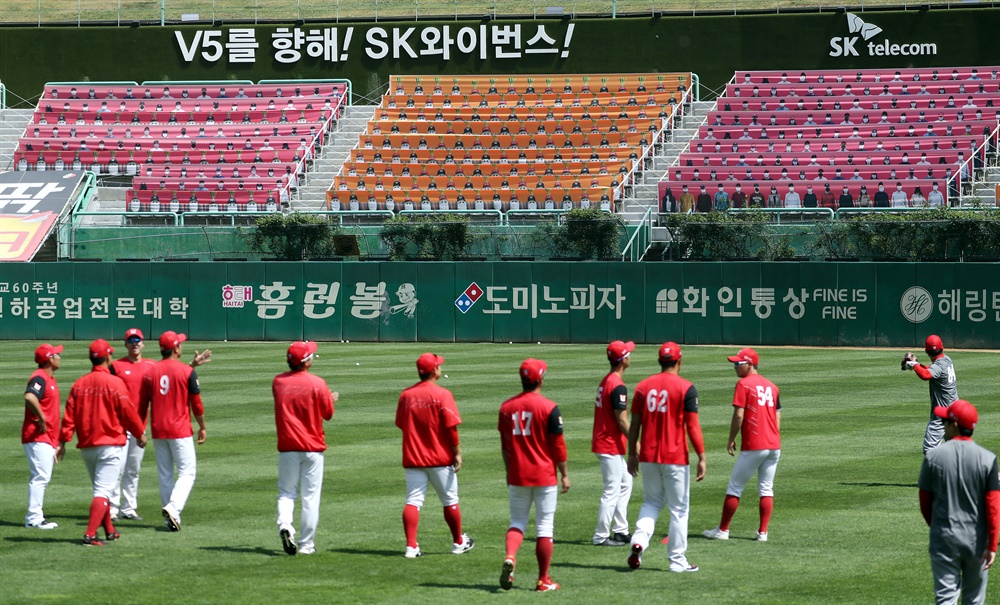 플래카드가 신기한 SK 선수들 프로야구 개막을 하루 앞둔 4일 오후 인천시 미추홀구 인천 SK행복드림구장에서 SK 와이번스 선수들이 관중석에 관중 대신 가득 찬 플래카드를 바라보고 있다. 내일 프로야구 개막전은 무관중 경기로 진행될 예정이다.