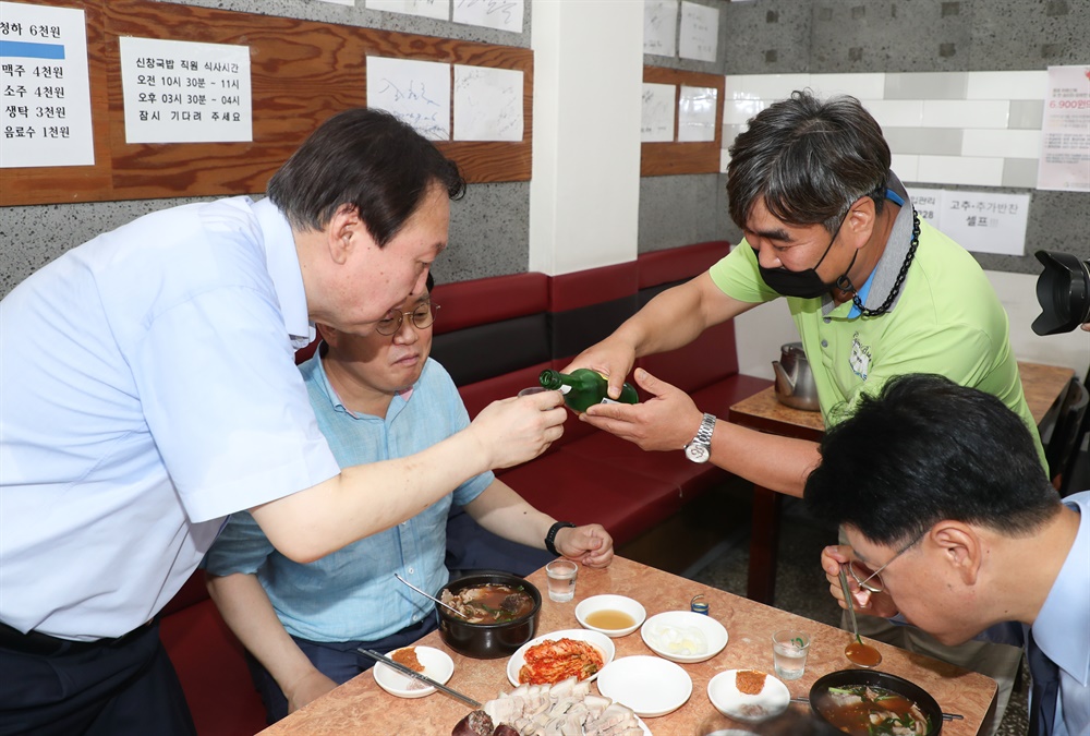  윤석열 전 검찰총장이 27일 낮 부산 서구에 있는 한 돼지국밥집에서 국민의힘 부산 국회의원들과 식사하면서 한 시민으로부터 소주를 받고 있다. 