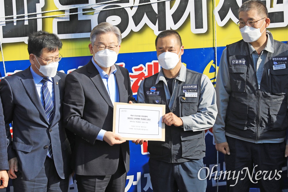  11월 14일 거제 대우조선해양 정문 앞에 있는 '매각 반대 천막농성장'을 찾은 이재명 후보가 신상기 대우조선지회장으로부터 '정책 공약 제안서'를 받고 있다.