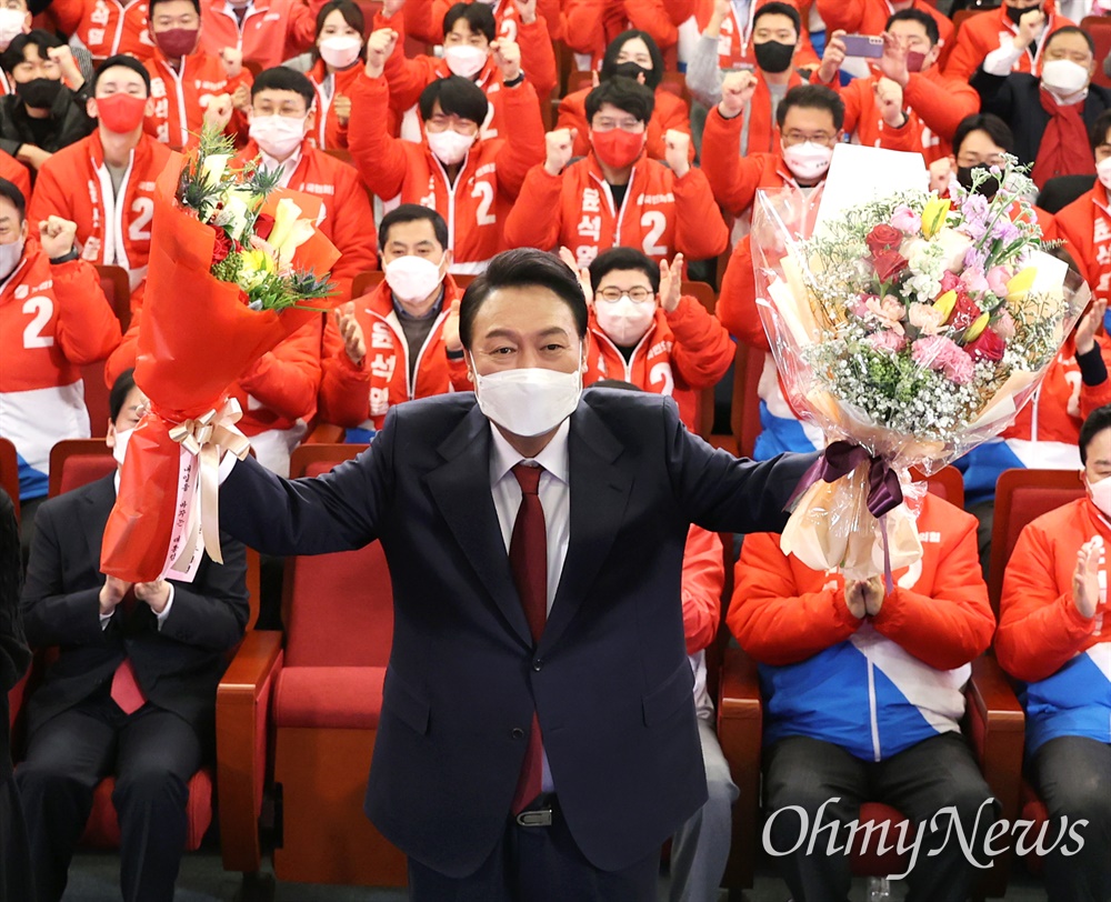  윤석열 국민의힘 대선 후보가 10일 새벽 서울 여의도 국회 도서관에 마련된 개표상황실을 찾아 당선 축하 꽃다발을 받아들고 있다.