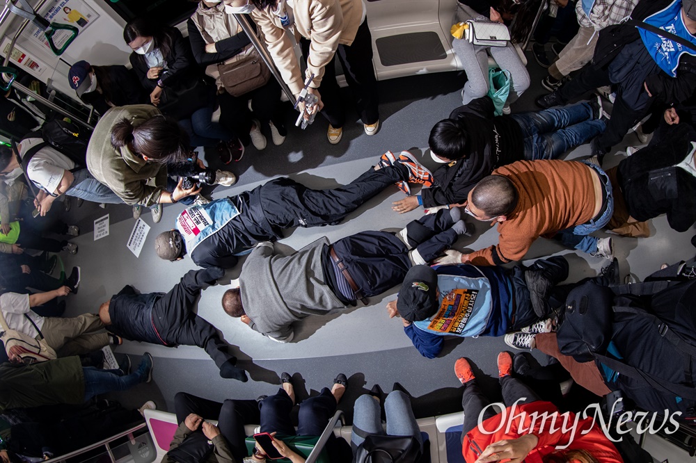  전국장애인차별철폐연대 활동가들이 21일 오전 서울 중구 2호선 시청역사 내에서 지하철 탑승시위를 하고 있다.