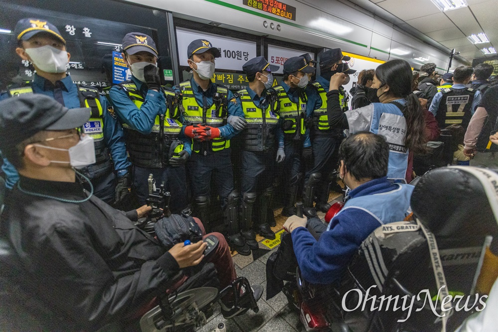  전국장애인차별철폐연대 활동가들이 21일 오전 서울 중구 2호선 시청역사 내에서 지하철 탑승시위를 하고 있다.