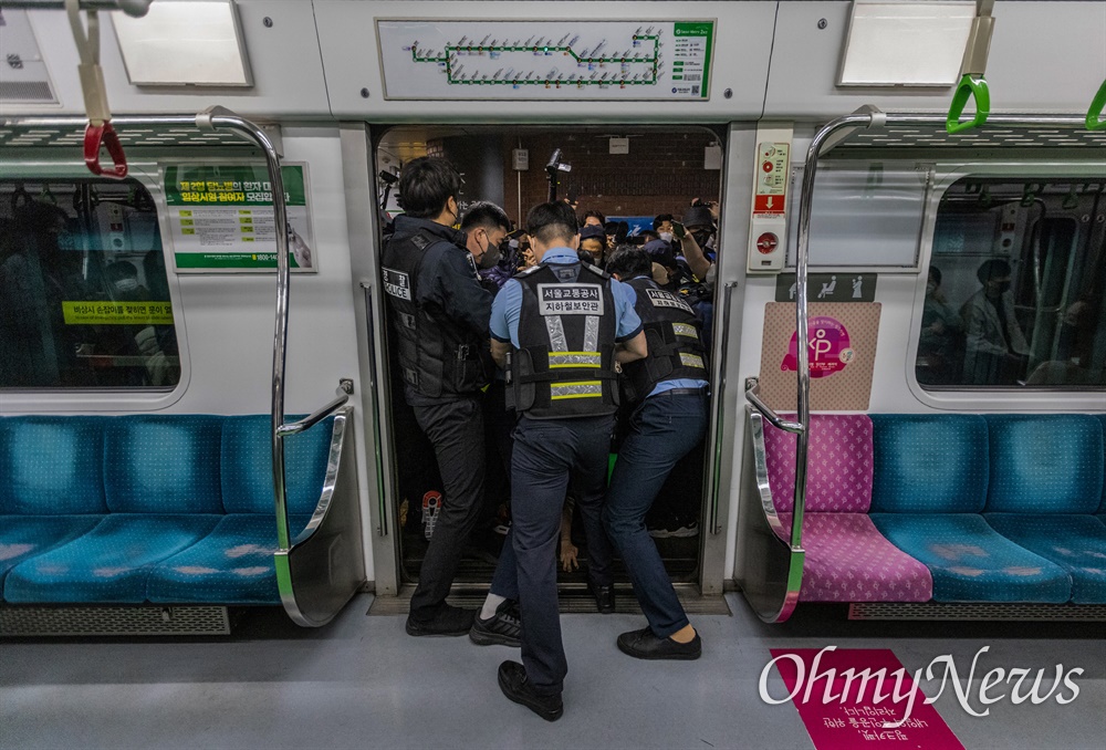  전국장애인차별철폐연대 활동가들이 21일 오전 서울 중구 2호선 시청역사 내에서 지하철 탑승시위를 하려하자 경찰과 서울교통공사 직원들이 입구를 봉쇄하고 있다. 