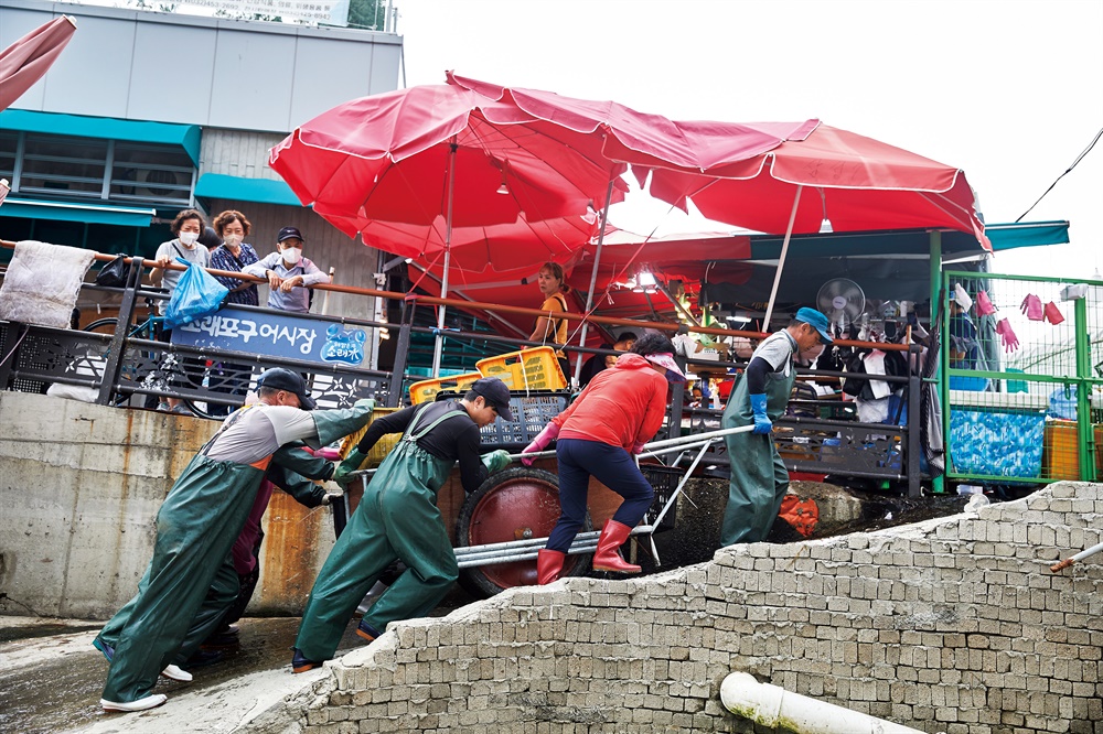  '천광호' 사람들이 꽃게를 배에서 내려 경매장으로 옮기고 있다.