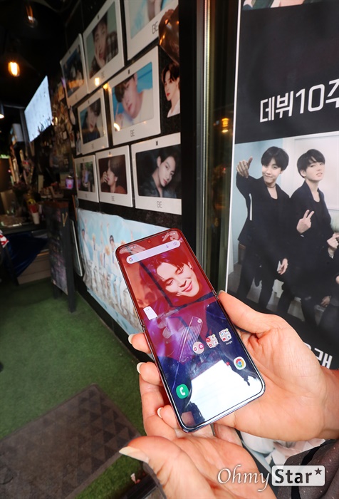 방탄소년단 10주년 방탄소년단 10주년을 맞아 14일 오후 서울 용산구 하이브 사옥 인근 카페에서 아미들이 방탄소년단의 사진과 구즈를 배경으로 기념촬영을 하고 있다.