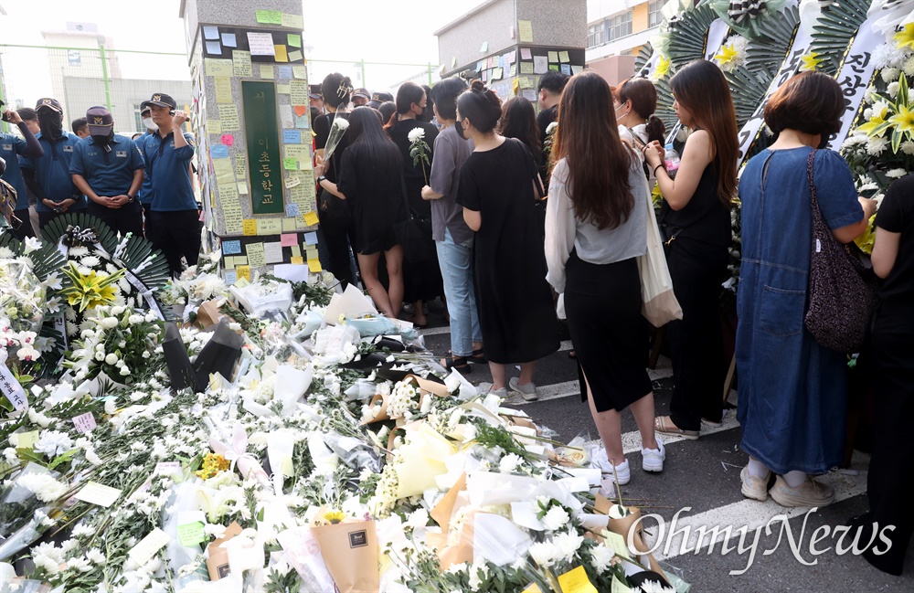  20일 오후 서울 서초구 S초등학교 앞에 1학년 교사의 죽음을 애도하는 발걸음이 이어지고 있는 가운데, 경찰이 학교 측의 요청을 받아 추모객들의 교내 입장을 가로막고 있다.