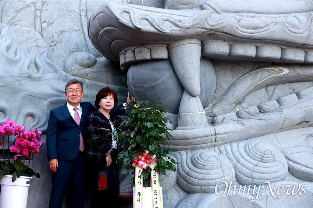  대한불교 조계종 방어산 마애사에 있는 대형 바위에 새겨진 청룡. 박일호 밀양시장이 부인과 함께 찾아 여의주를 만져보고 있다.