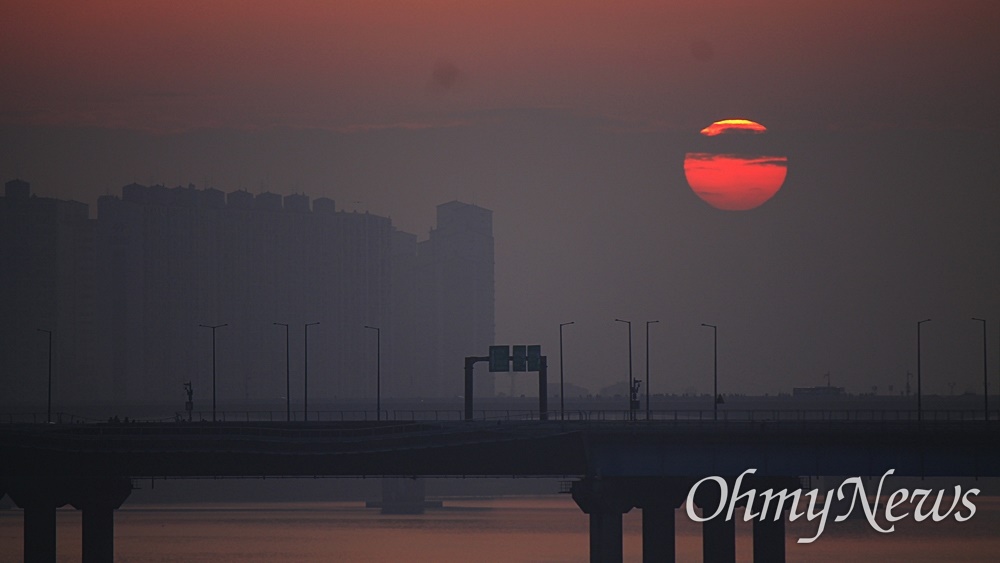  2024년 1월 1일 첫 일출. 서울 하늘 짙게 깔린 구름 위로 태양이 떠오르고 있다. 서강대교 위에서 바라본 장면.