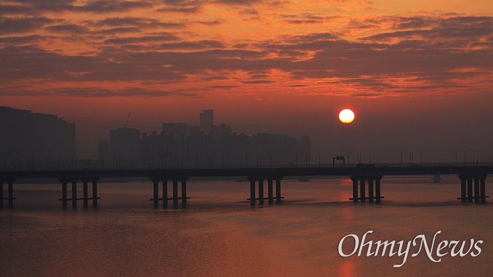  2024년 1월 1일 첫 일출. 서울 하늘 짙게 깔린 구름 위로 태양이 떠오르고 있다. 서강대교 위에서 바라본 장면.
