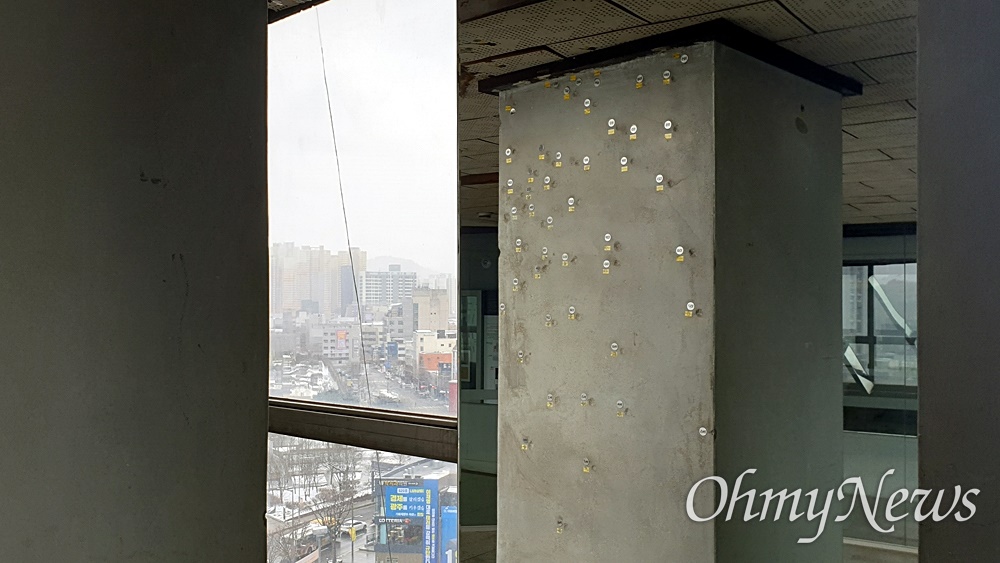  전일빌딩245 10층 기둥에 남은 총탄 자국. 왼쪽 벽에 남은 탄흔을 오른쪽 거울에 비춰서 보여주고 있다.