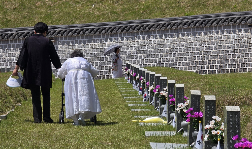  제44주년 5·18민주화운동 기념식이 열린 18일 오전 광주광역시 북구 운정동 국립 5·18민주묘지에서 윤영규 열사의 아내와 가족이 참배를 마치고 묘지를 나서고 있다.