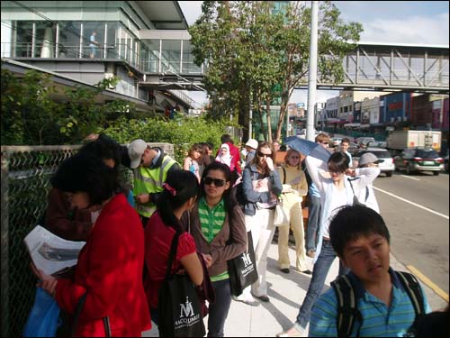 '버스는 언제 오려나.' 부시 미국 대통령을 비롯해 APEC에 참여하는 주요 국가 정상들의 경호를 위해 설치한 바리케이드와 철조망 장벽 때문에 시민들이 불편을 겪고 있다.